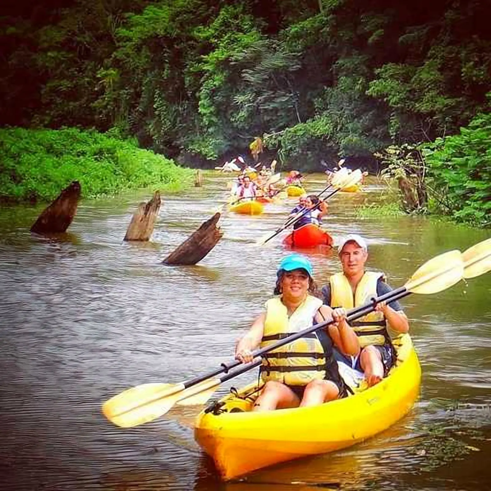 Couple paddling a yellow kayak